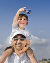 Boy on father shoulders with toy airplane