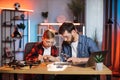 Boy with father soldering together details from laptop