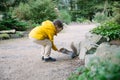 a boy feeding a friendly squirrel in a park, making friends with animals in Ireland