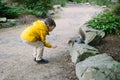 a boy feeding a friendly squirrel in a park