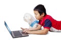 Boy feeding his Bolognese dog while using laptop Royalty Free Stock Photo