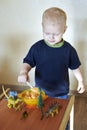 A boy feeds a toy dinosaur porridge from a spoon Royalty Free Stock Photo