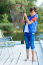 Boy feeling amazing after catching fish while holding net
