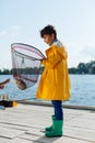 Boy feeling surprised while seeing fish in the fishing net