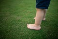 Boy feet in nature. bare feet in the green grass. little Happy child running at sunset barefoot outdoor. Royalty Free Stock Photo