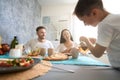 Kid taking care of his parents by pouring them tea Royalty Free Stock Photo