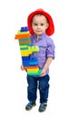 A boy in a fireman`s helmet with bunch of toys in his hands Royalty Free Stock Photo