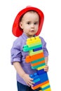 A boy in a fireman`s helmet with bunch of toys in his hands Royalty Free Stock Photo