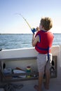 Boy fishing from a boat. Royalty Free Stock Photo