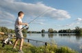 Boy fishing on a lake. Beautiful fish pond in Badin, near Banska Bystrica, Slovakia. Fishing place. Shining sun over the fish pond Royalty Free Stock Photo