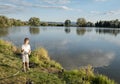 Boy fishing on a lake. Beautiful fish pond in Badin, near Banska Bystrica, Slovakia. Fishing place. Shining sun over the fish pond Royalty Free Stock Photo