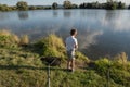 Boy fishing on a lake. Beautiful fish pond in Badin, near Banska Bystrica, Slovakia. Shining sun over the fish pond in summer day Royalty Free Stock Photo