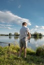 Boy fishing on a lake. Beautiful fish pond near Badin, Banska Bystrica, Slovakia. Fishing place. Shining sun over the fish pond in Royalty Free Stock Photo