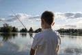 Boy fishing on a lake. Beautiful fish pond near Badin, Banska Bystrica, Slovakia. Fishing place. Shining sun over the fish pond in Royalty Free Stock Photo