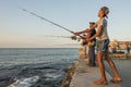 Boy fishing Malecon sunset Havana