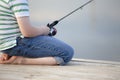 Boy fishing off dock in summer Royalty Free Stock Photo