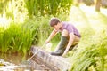 Boy Fishing In Pond With Net And Jar Royalty Free Stock Photo