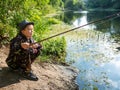 Boy with a fishing rod catches a fish Royalty Free Stock Photo