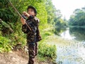 Boy with a fishing rod catches a fish Royalty Free Stock Photo