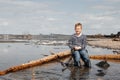 A boy with a fishing rod catches fish sitting on the river bank Royalty Free Stock Photo