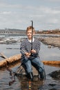 A boy with a fishing rod catches fish sitting on the river bank Royalty Free Stock Photo