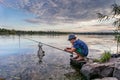 Boy with a fishing rod catches a fish Royalty Free Stock Photo