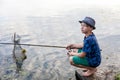 Boy with a fishing rod catches a fish Royalty Free Stock Photo