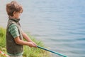 A boy with a fishing rod fishes on the lake,a river,a sea Royalty Free Stock Photo