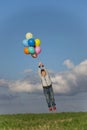 The boy flies away in balloons