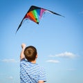 Boy flies kite into blue sky Royalty Free Stock Photo