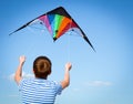 Boy flies kite into blue sky Royalty Free Stock Photo