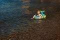 The boy floating on an inflatable baby boat Royalty Free Stock Photo