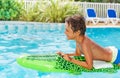 Boy floating on inflatable toy in swimming pool Royalty Free Stock Photo