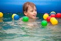 Boy floats in inflatable pool with balls Royalty Free Stock Photo