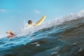 Boy floats on surf board over the wave crest