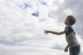 Boy flying a paper plane against blue sky Royalty Free Stock Photo