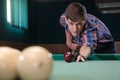 Boy in focus aiming for shot the billiard ball