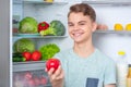 Boy with food near fridge Royalty Free Stock Photo