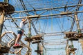 Boy in forest adventure park. Kid in orange helmet and white t shirt climbs on high rope trail. Climbing outdoor