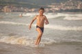 Boy frolics in the sea with splashes and waves