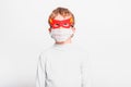 A boy with a fun superhero mask to protect himself from the viral infections of the disease