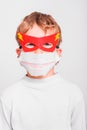 A boy with a fun superhero mask to protect himself from the viral infections of the disease