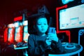 The boy in the game center shoots himself on video on the phone. Neon lighting. Boy blogger