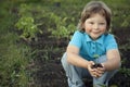 Boy in the garden admires the plant before planting. Green Sprout in Children Hands