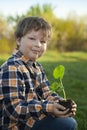 Boy in the garden admires the plant before planting. Green Sprout in Children Hands