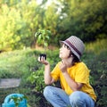 Boy in the garden admires the plant before planting. Green Sprout in Children Hands