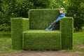 Boy on the giant grass armchair, park landscape decoration