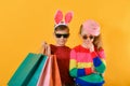 Boy and girl in bright and colorful clothes and sunglasses with shopping bags, concept of children`s shopping Royalty Free Stock Photo