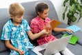 Boy and girl, brother and sister study at home. A girl watches a video lesson or an online conference, a boy does
