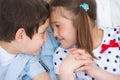 Boy and girl bumping heads against each other